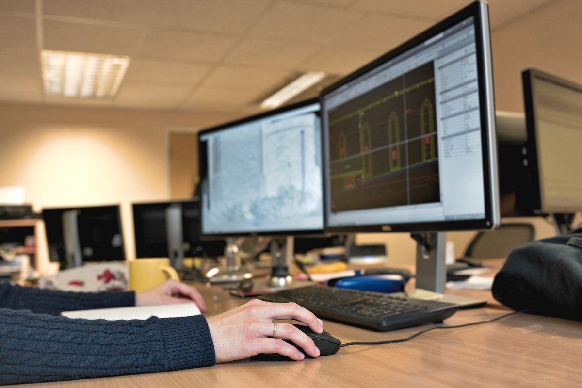 Woman's hand holding a mouse for office design work. Female architect designing building