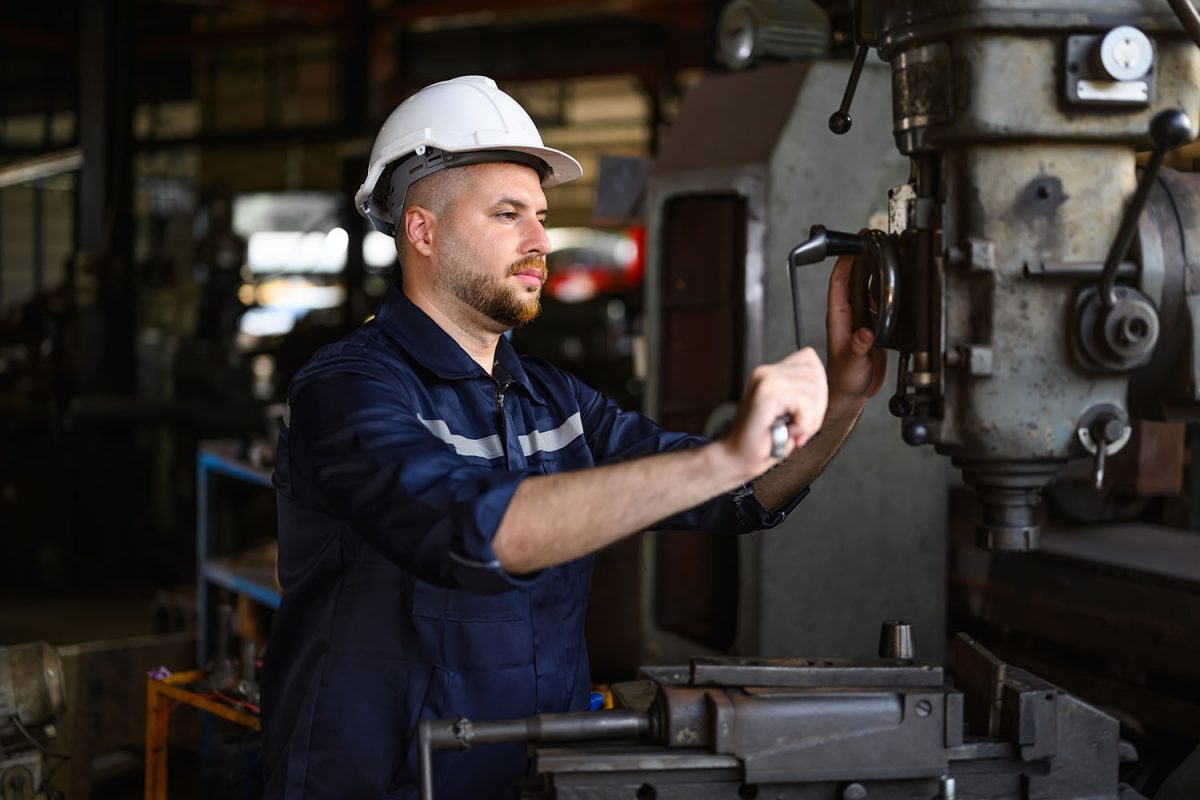 Professional male technician engineer checking and controlling machine at manufacturing factory